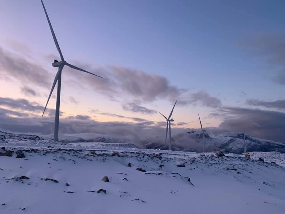 Wind turbines in a snow-covered mountainous landscape